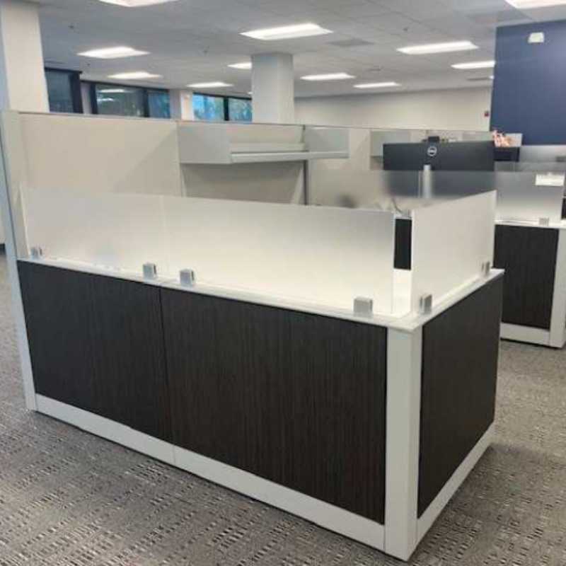 Dark wood grain laminate cubicles with frosted glass top panels in modern office installation
